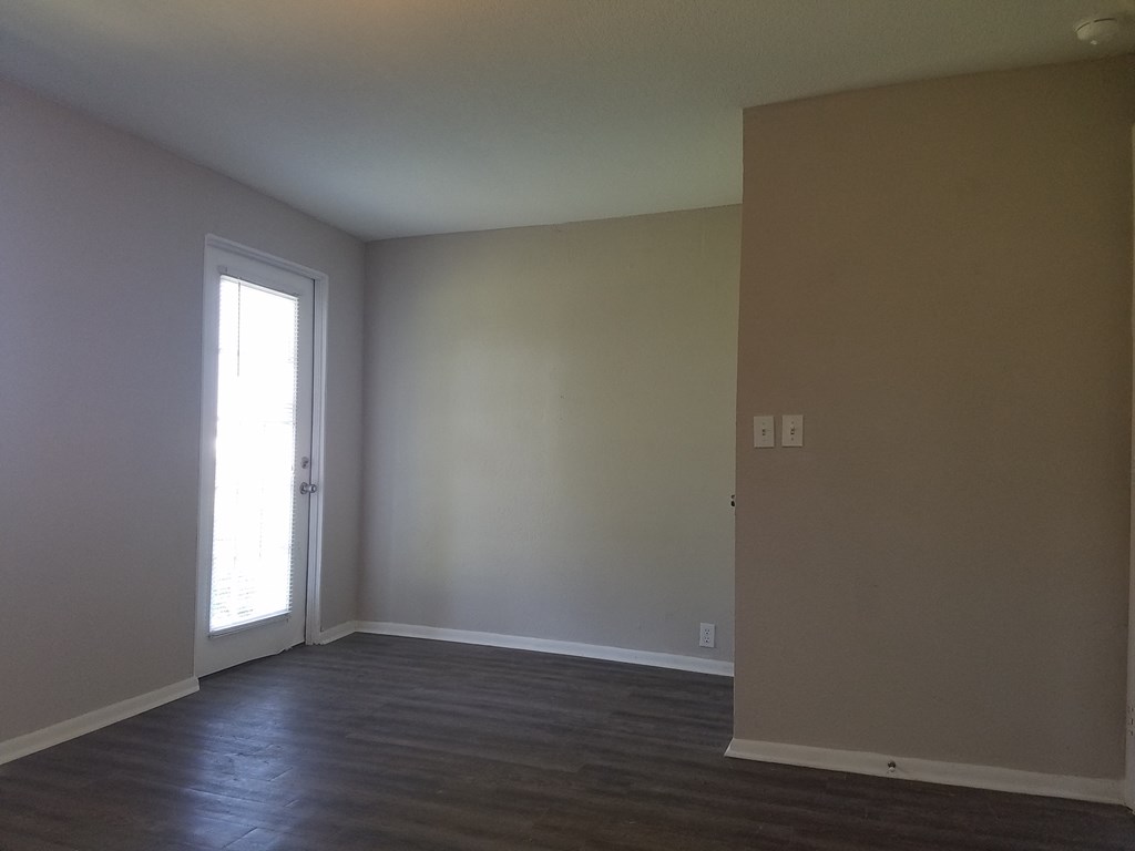 an empty living room with white walls and a door
