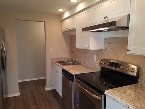 a kitchen with white cabinets and a black stove top oven