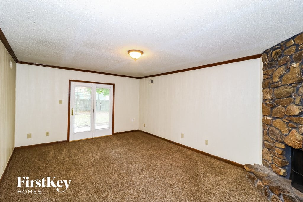 a living room with a fireplace and a stone wall