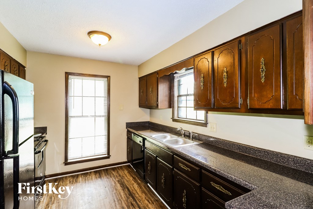 a kitchen with wooden cabinets and a sink and a refrigerator