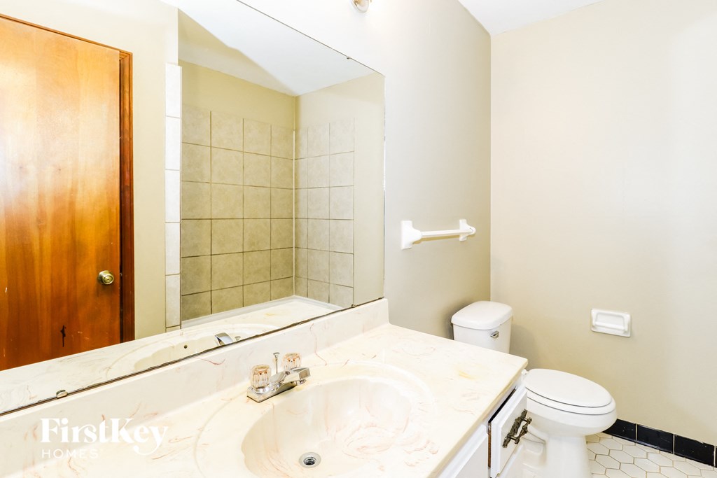 a bathroom with a sink toilet and a mirror