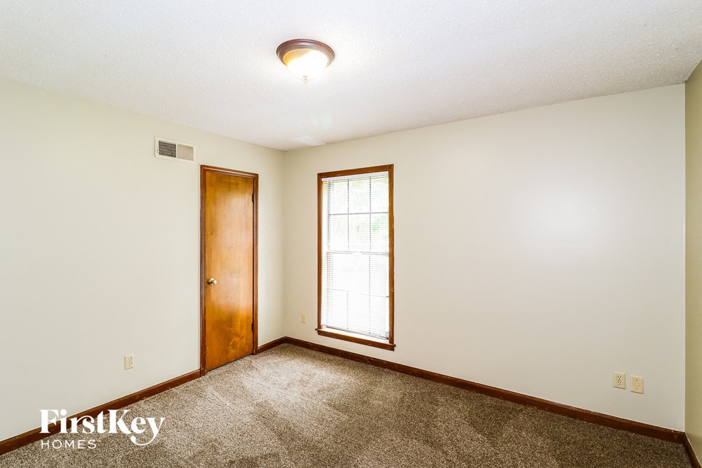the master bedroom is spacious and clean with carpeting and a window