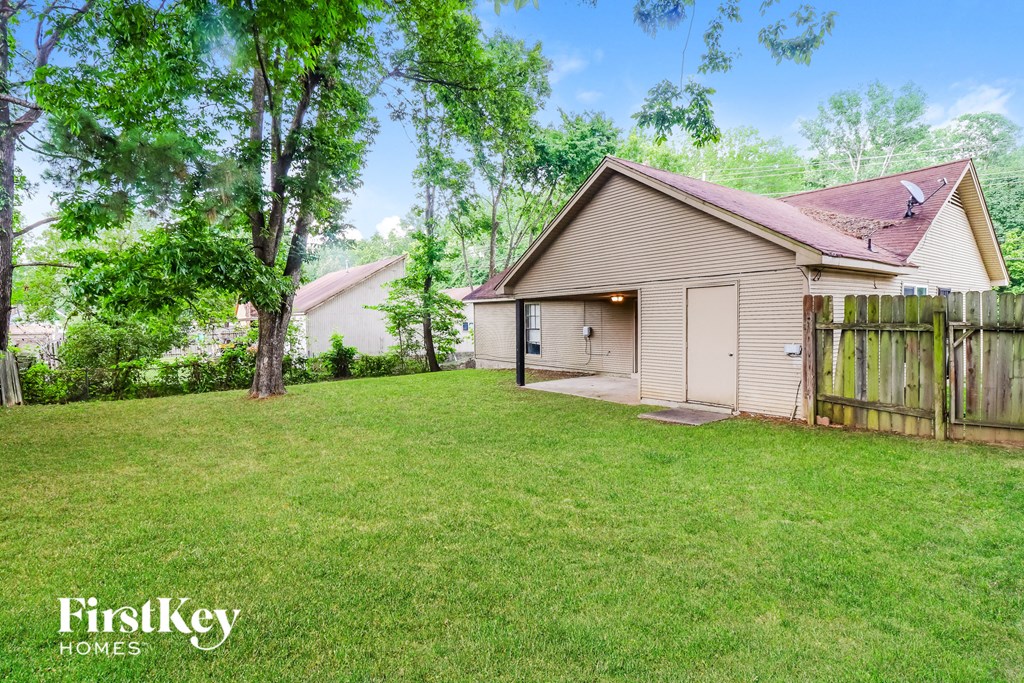 a backyard with a house and a yard with a fence