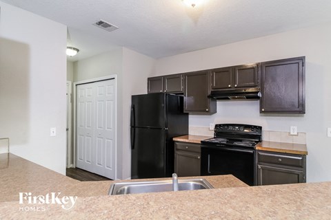a kitchen with black appliances and a black refrigerator