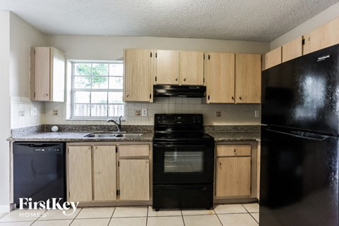 a kitchen with black appliances and wooden cabinets