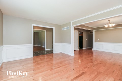 an empty living room with wood floors and white walls