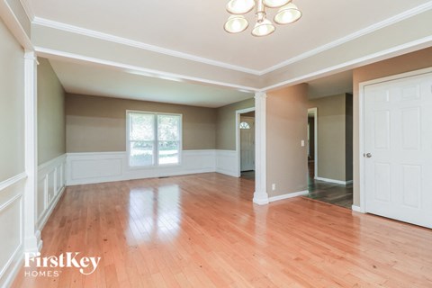 an empty living room with wood floors and white walls
