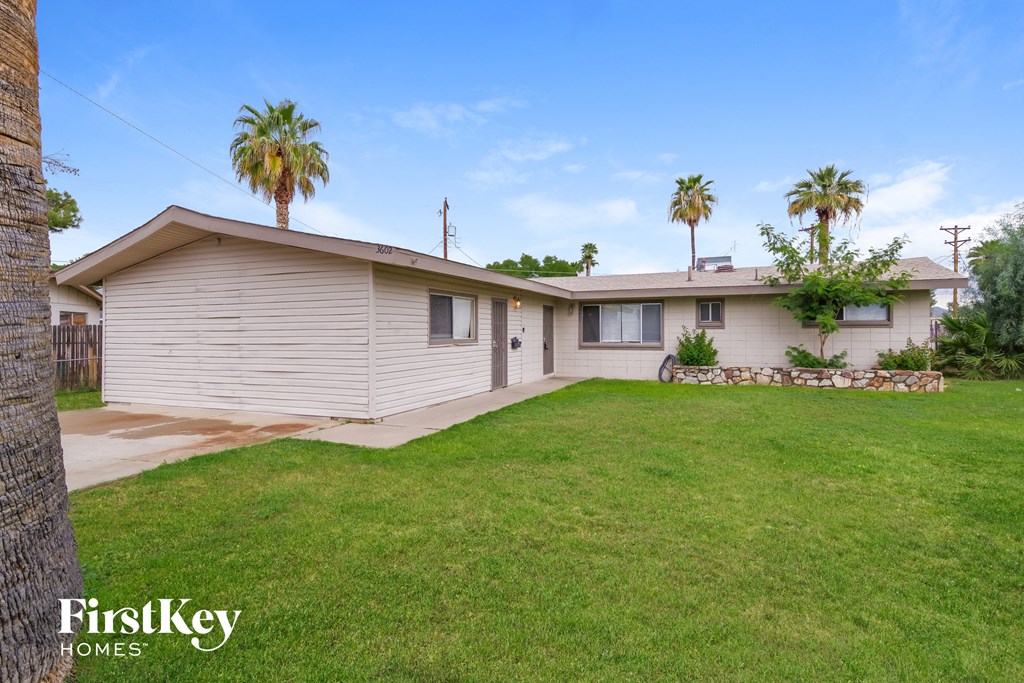 a white house with palm trees and a lawn