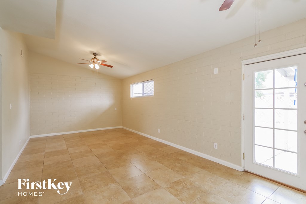 the living room is spacious and clean with a ceiling fan