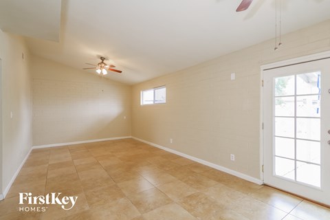 the living room is spacious and clean with a ceiling fan