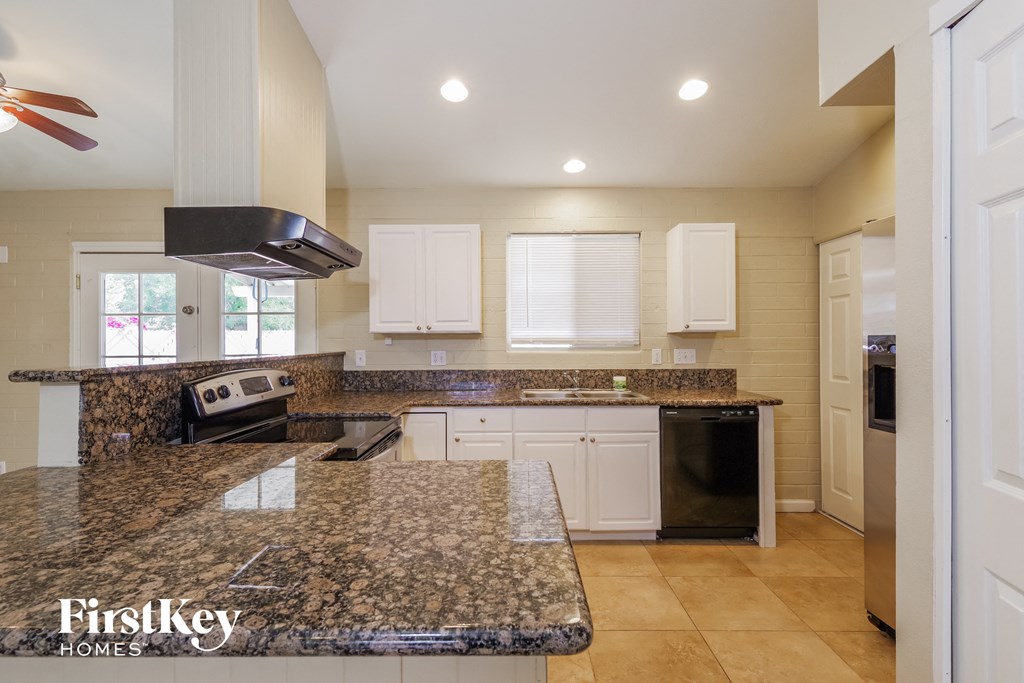 a kitchen with granite counter tops and white cabinets