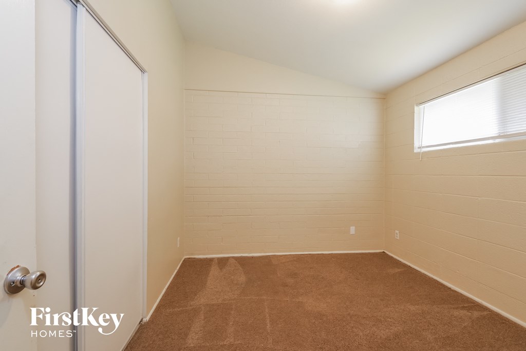 a small room with a door to a closet and a window