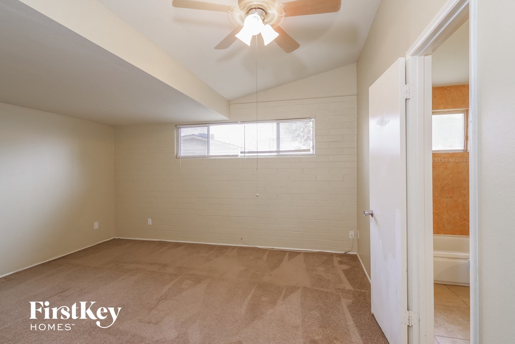 the living room of an empty house with a ceiling fan