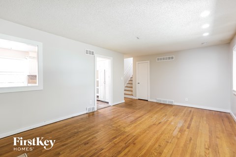 a living room with a hard wood floor and white walls