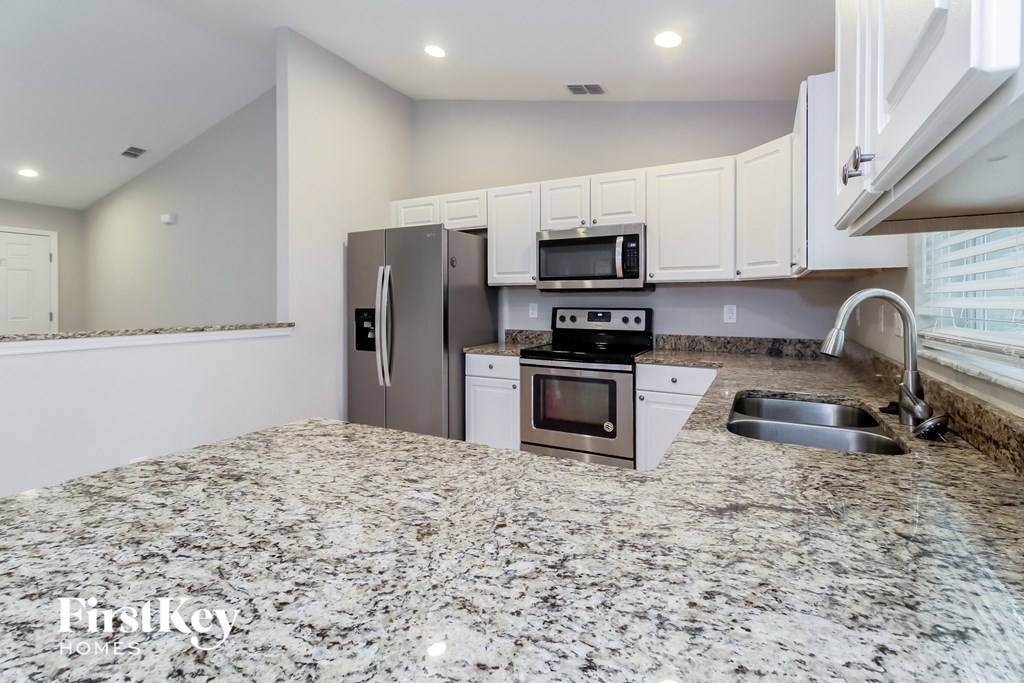 a kitchen with granite counter tops and stainless steel appliances