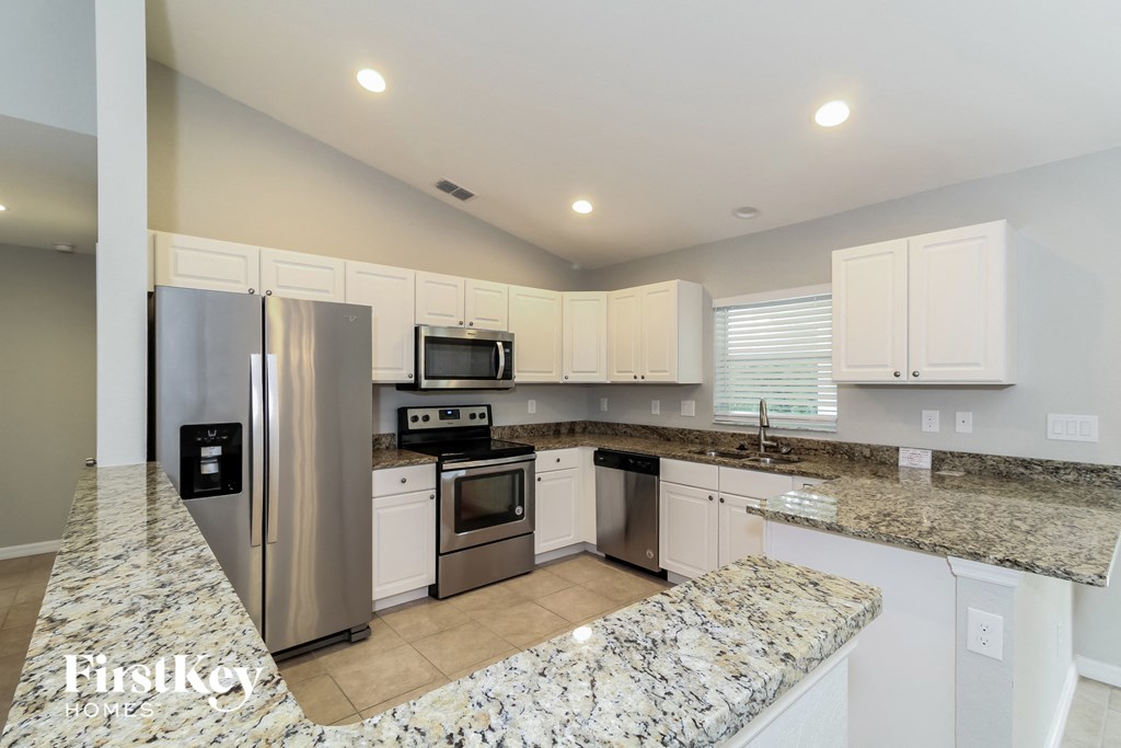 a large kitchen with granite counter tops and stainless steel appliances