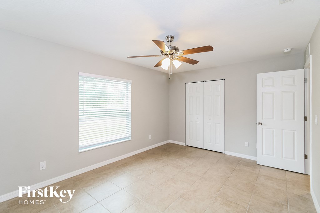 a living room with a ceiling fan and a tiled floor