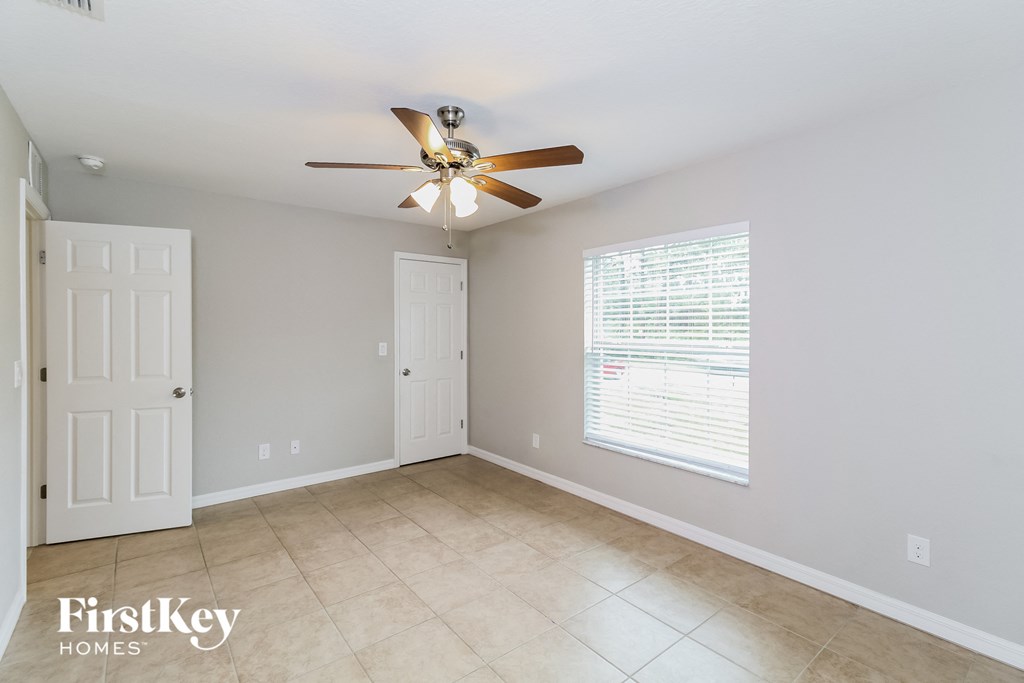 an empty room with a ceiling fan and a door
