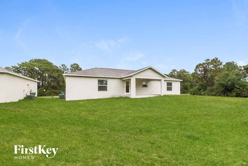 a white house on a hill with a grassy yard