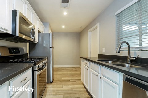 A kitchen with white cabinets and stainless steel appliances.