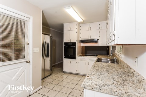 a kitchen with white cabinets and a granite counter top