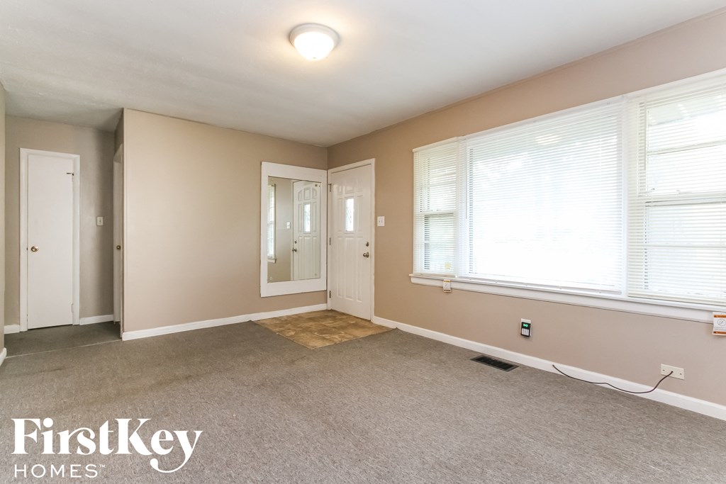 a bedroom with a carpeted floor and a door to the bathroom