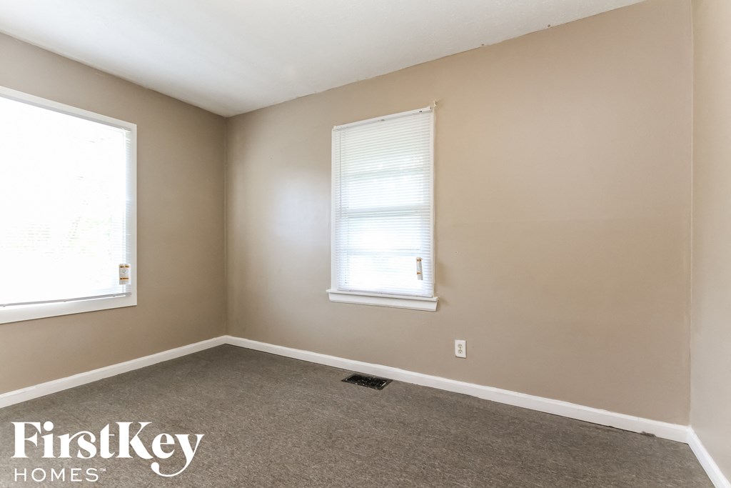 an empty room with a window and a carpet