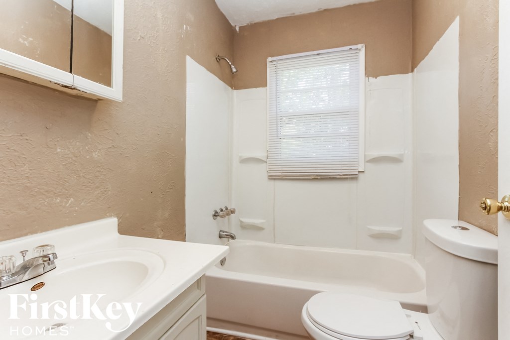 a bathroom with a sink toilet and a bath tub