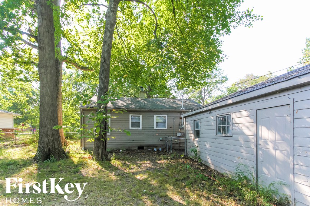 a backyard with a house and a shed and trees