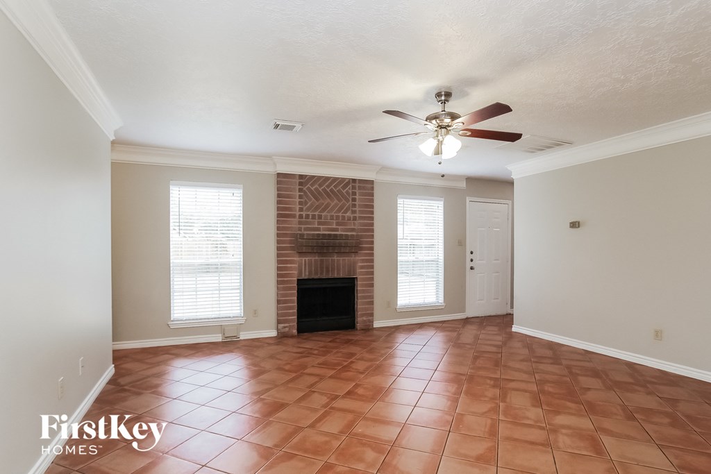 a living room with a fireplace and a ceiling fan