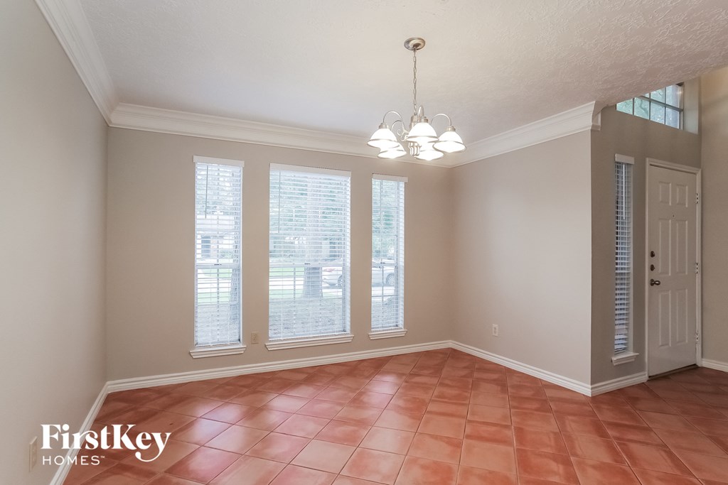 a formal dining room with windows and a door to a patio