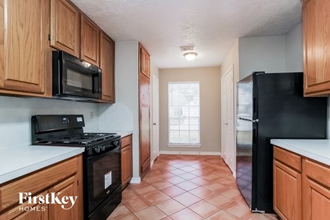 a kitchen with wood cabinets and black appliances and a window