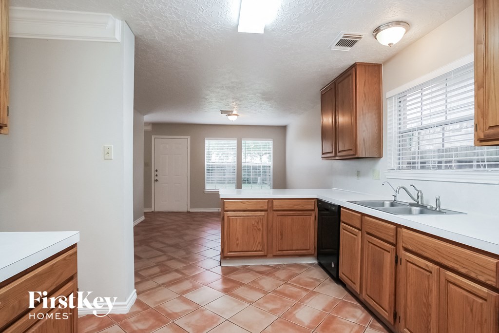 a kitchen with wooden cabinets and a sink and a window