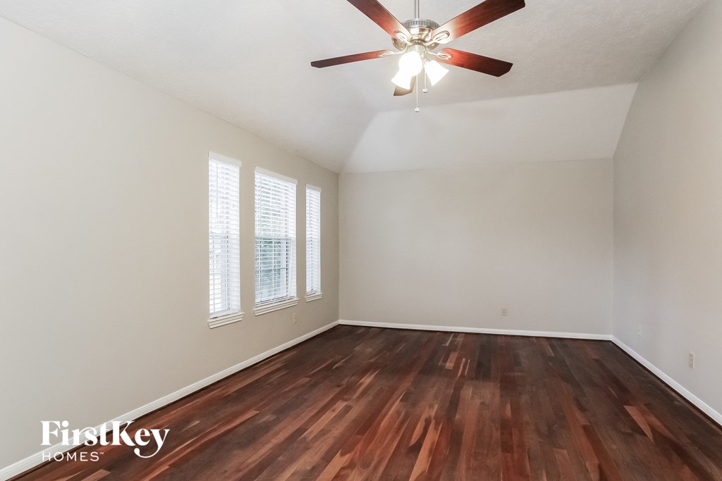 a living room with hardwood floors and a ceiling fan