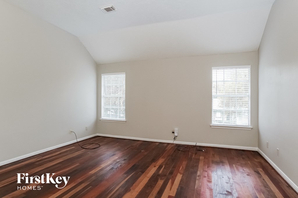 the living room with hardwood flooring and two windows