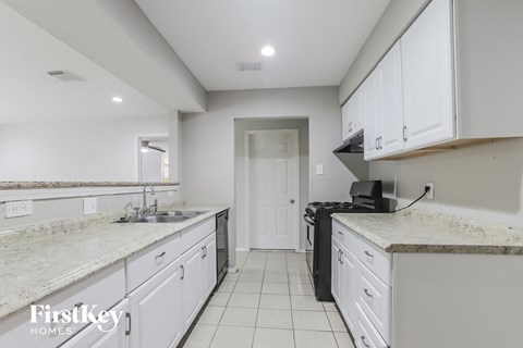 a kitchen with white cabinets and white counter tops and a sink