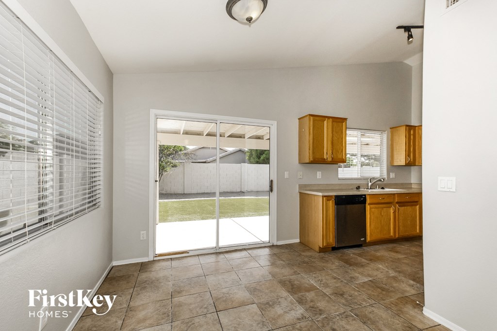 a kitchen with a sliding glass door to the backyard