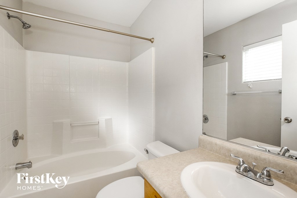 a bathroom with a sink toilet and shower and a mirror