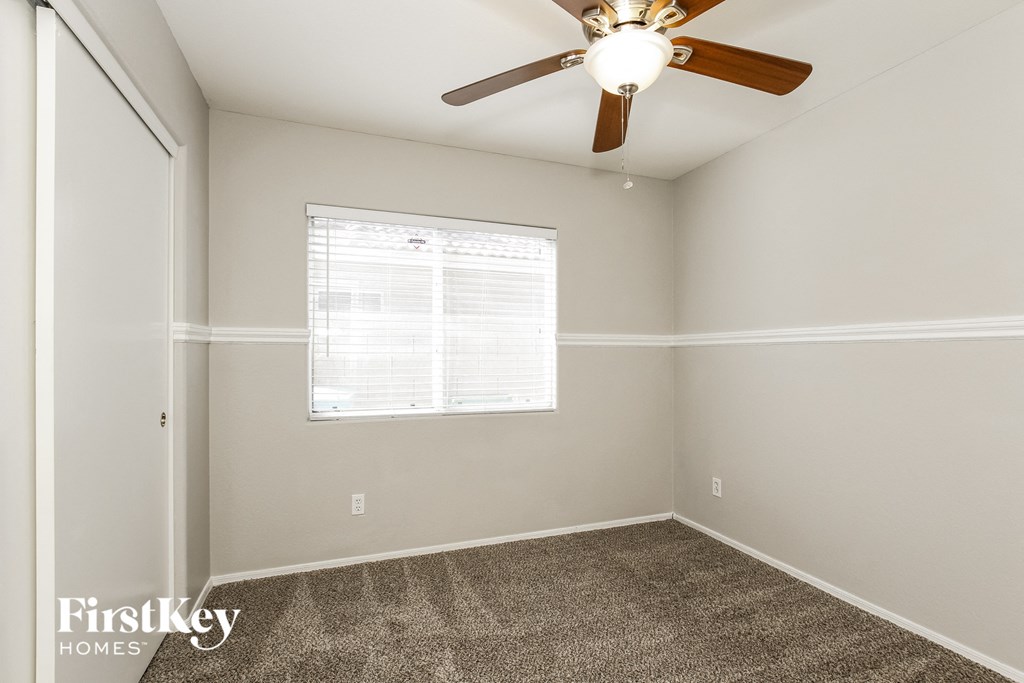 a bedroom with a ceiling fan and a window