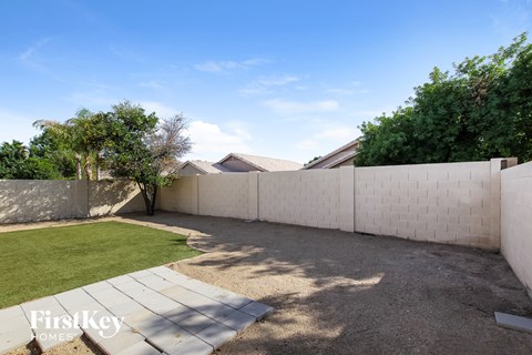the backyard of a house with a fence and grass
