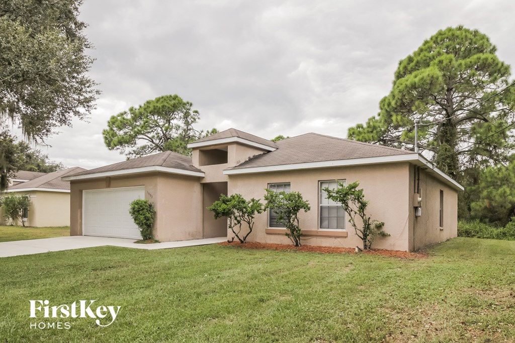 a beige house with a lawn and a garage