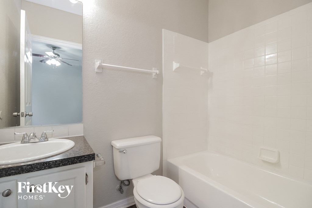 a white bathroom with a tub and a toilet and a sink