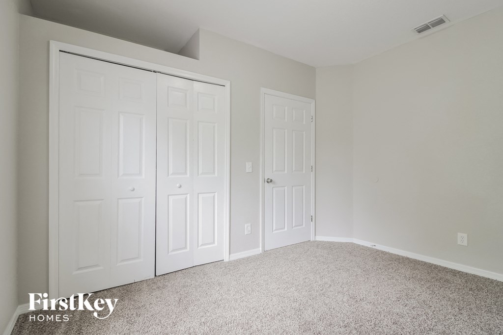 a bedroom with two closets and a carpeted floor
