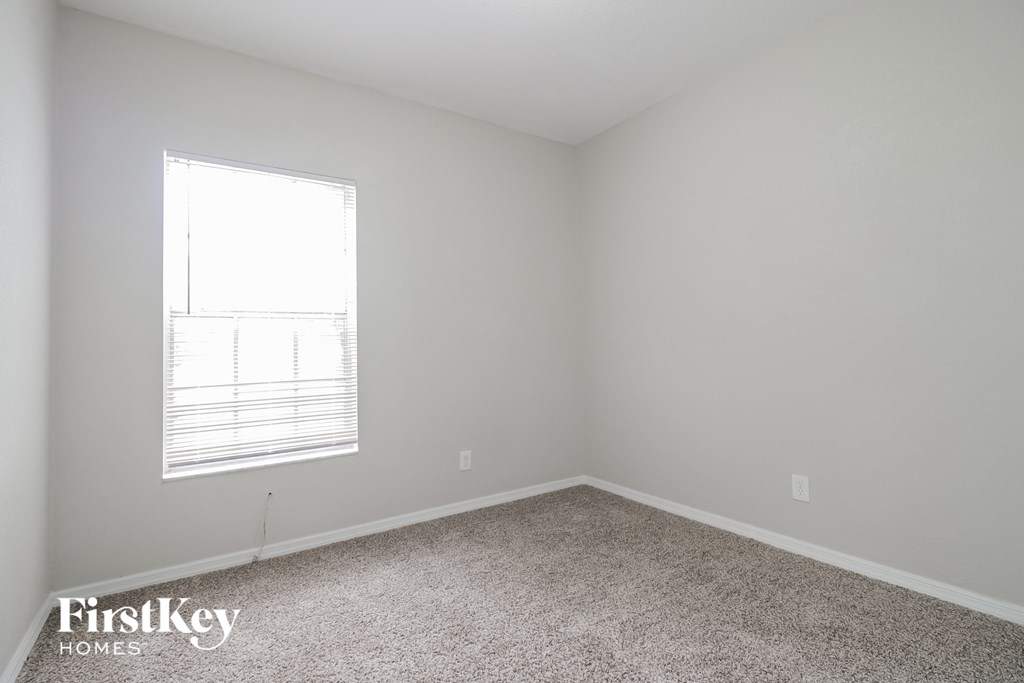 a small room with a window and a carpet