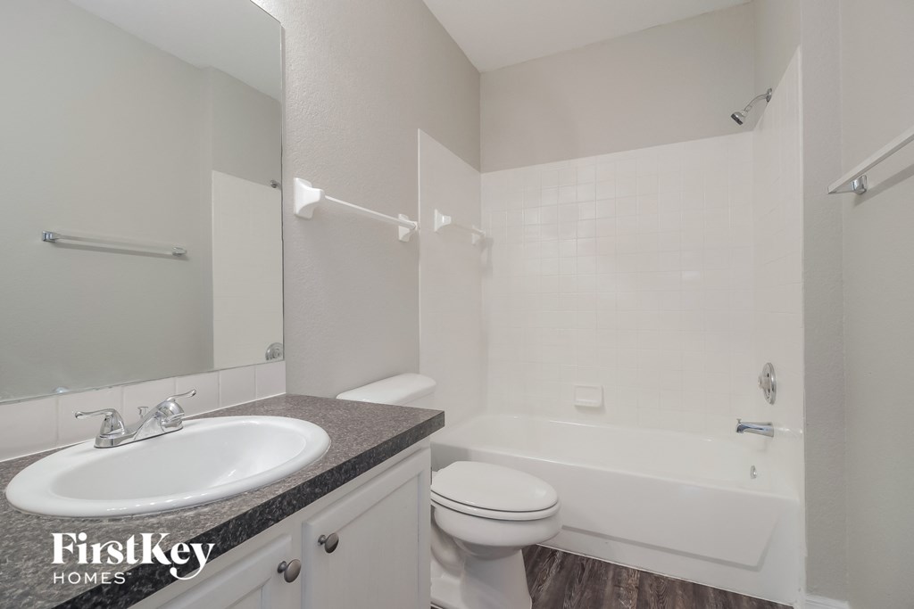 a white bathroom with a sink toilet and shower