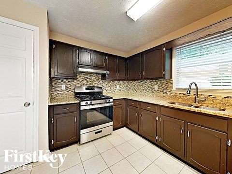 A kitchen with brown cabinets and a stove top oven.