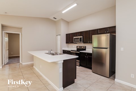 A kitchen with a stainless steel refrigerator and a white countertop.