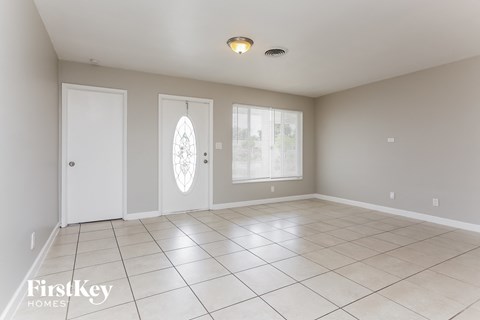 a living room with a tiled floor and two doors