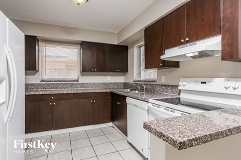 a kitchen with granite counter tops and white appliances