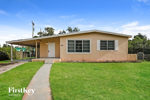 A single-story house with a white door and windows is for sale.